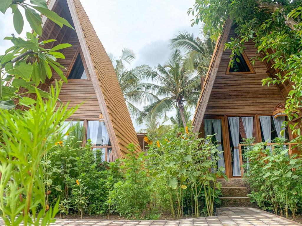 una casa con un montón de plantas delante de ella en Kubu Penida Villa en Nusa Penida