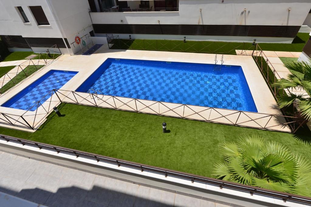 an overhead view of a large swimming pool with grass at Apartamento CERCA PLAYA CON BALCON Y BBQ in Calafell