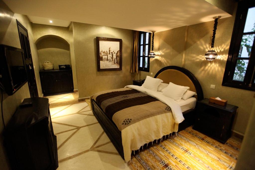 a bedroom with a bed and a tv in it at Riad Dar Haven in Tamraght Ou Fella