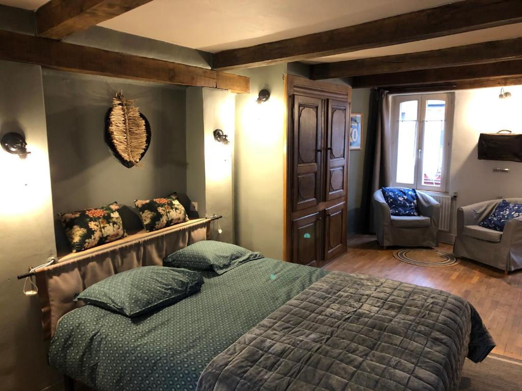 een slaapkamer met een groot bed en een stoel bij La ruelle in Durbuy