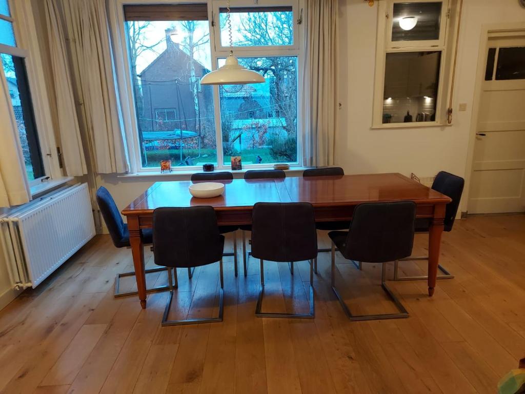 mesa de comedor con sillas y ventana grande en huisje Nieuw Vliet, en Nieuwvliet
