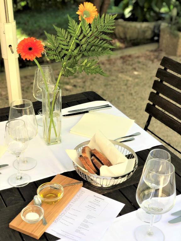 a table with a bowl of bread and a vase with flowers at Hotel Neufeld in Zürich