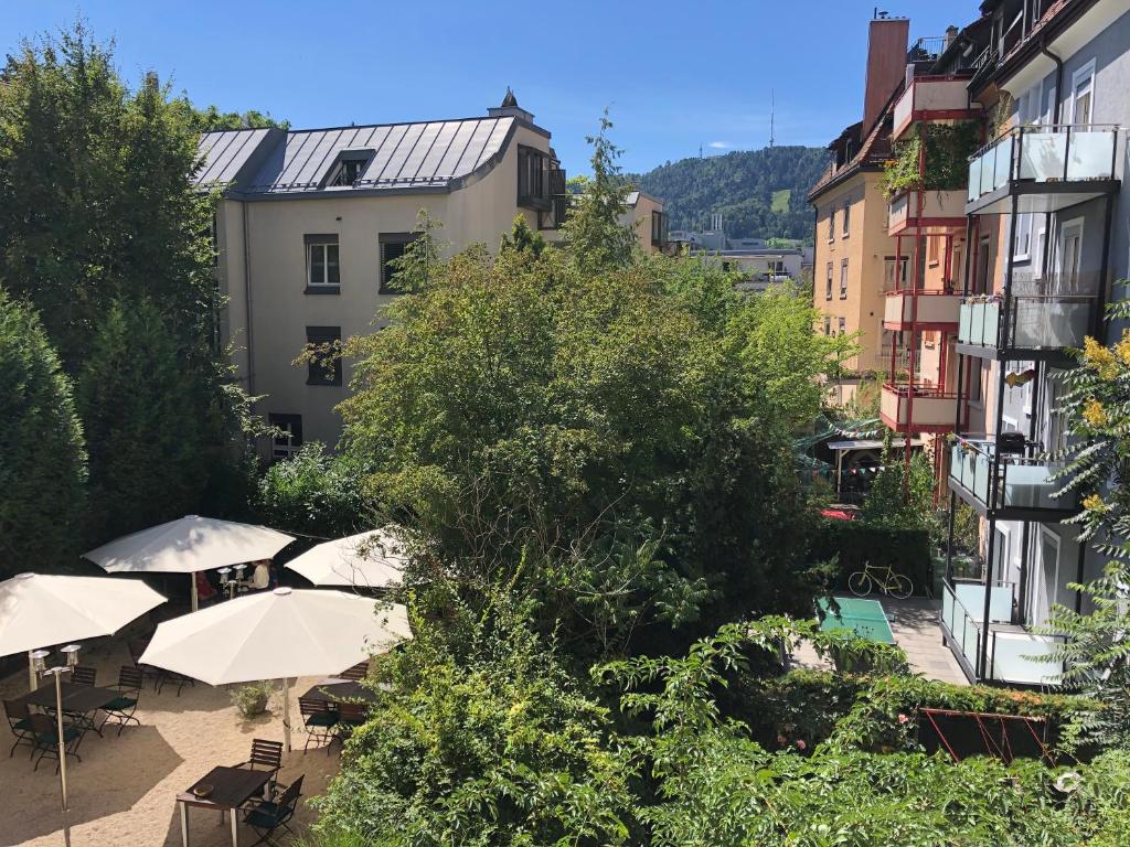 a group of tables and umbrellas in a city at Hotel Neufeld in Zürich
