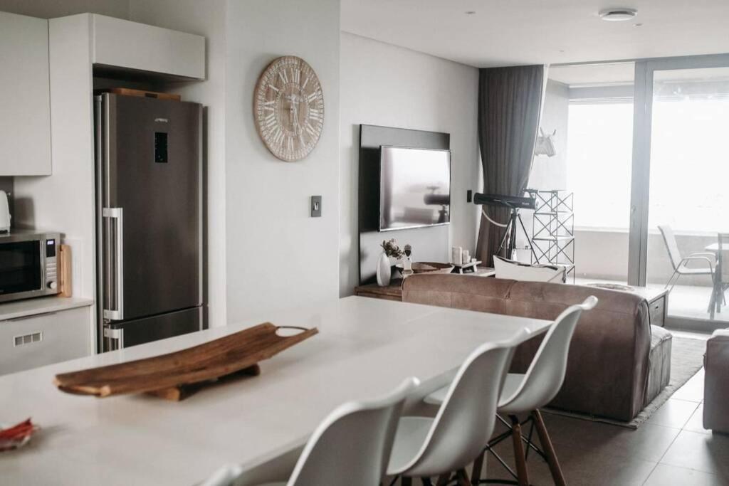 a kitchen with a table with chairs and a refrigerator at Luxury Apartment near the Airport with Sea View in Umhlanga