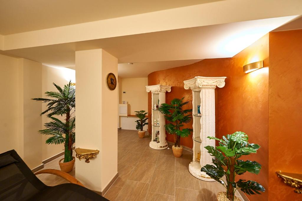 a living room with columns and potted plants at Hotel Belvedere in Warnemünde