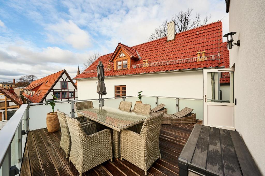 a patio with a table and chairs on a deck at Hotel Belvedere in Warnemünde