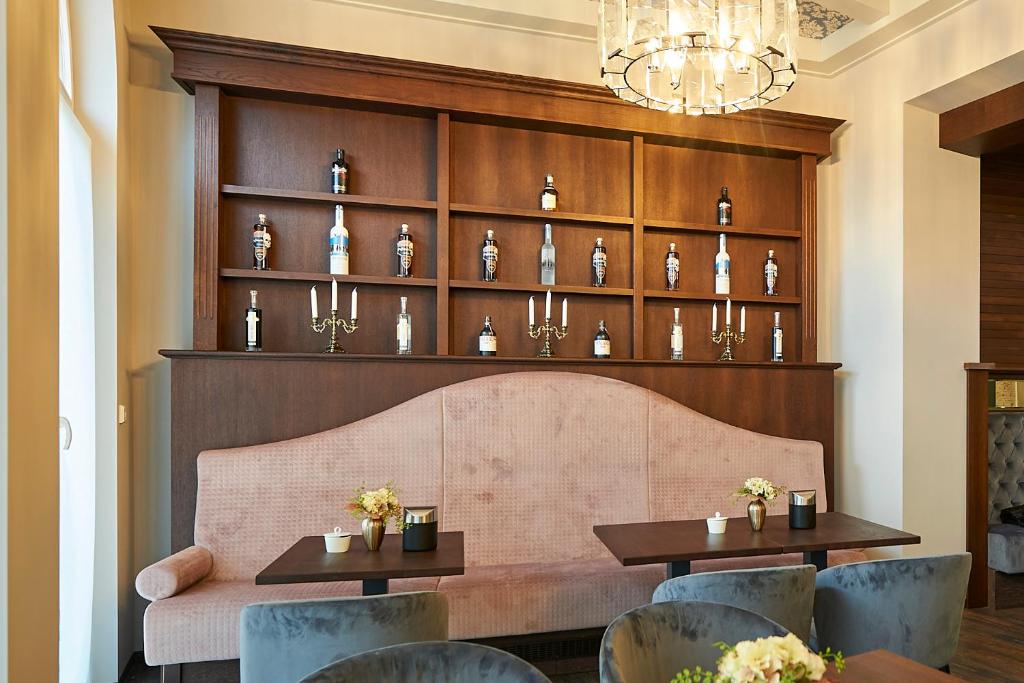 a restaurant with two tables and chairs and a shelf of vases at Hotel Belvedere in Warnemünde