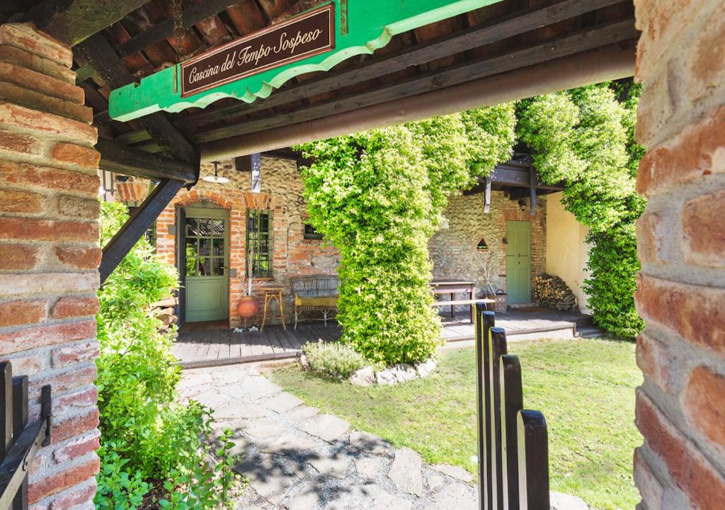 a brick building with a green door and ivy at Cascina del Tempo Sospeso in Bogogno