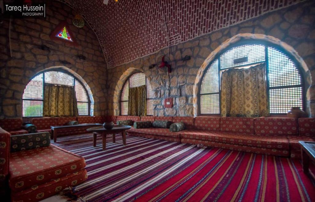 een grote kamer met een bank, een tafel en ramen bij Aliyah Eco-Lodge in Bawati