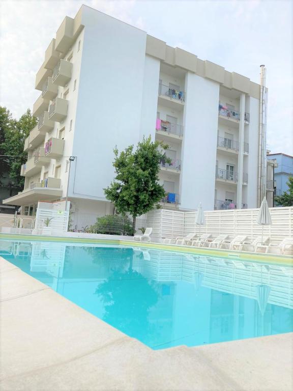 a swimming pool in front of a building at Hotel Villa del Parco in Rimini