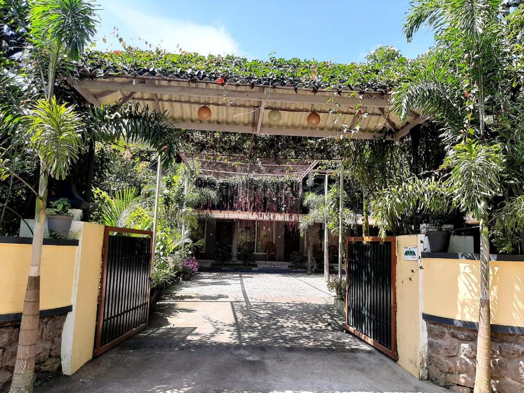 an entrance to a garden with a gate with plants on it at Anna Homestay in Munnar