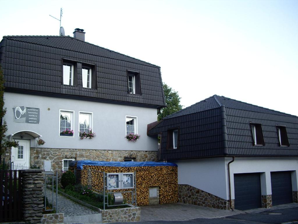 zwei Häuser mit schwarzen Dächern in der Unterkunft Studia Relax in Železná Ruda