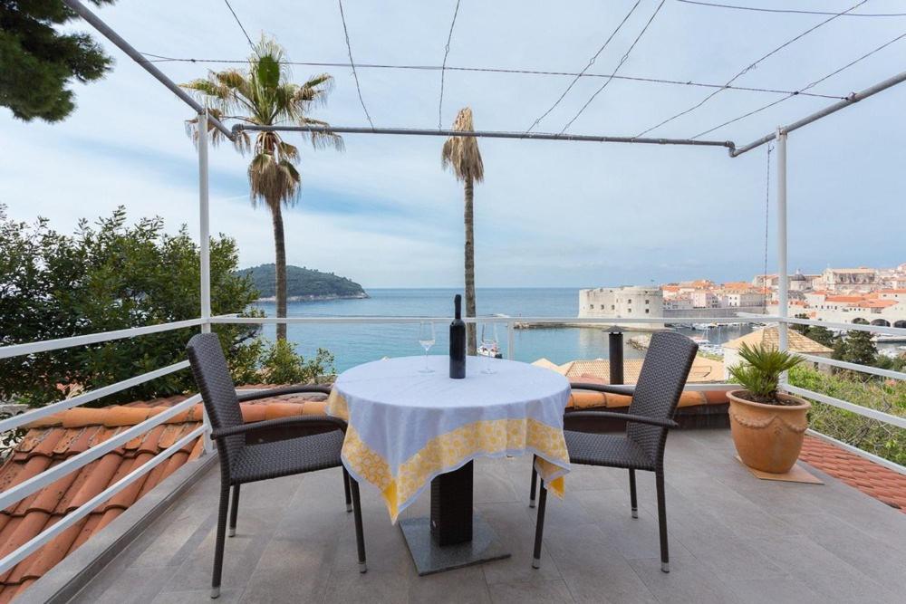 una mesa y sillas en un balcón con vistas al océano en Apartments Kalas, en Dubrovnik