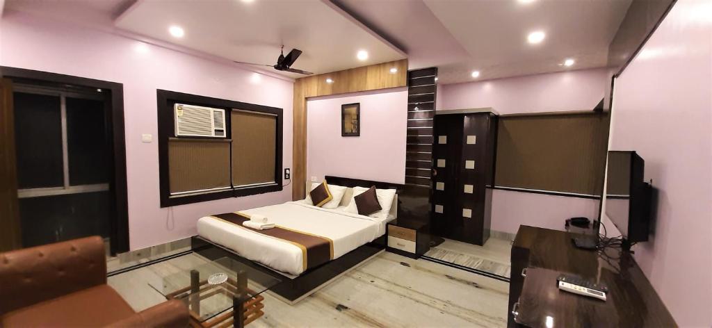 1 dormitorio con cama, mesa y escritorio en DORA HOUSE, en Calcuta