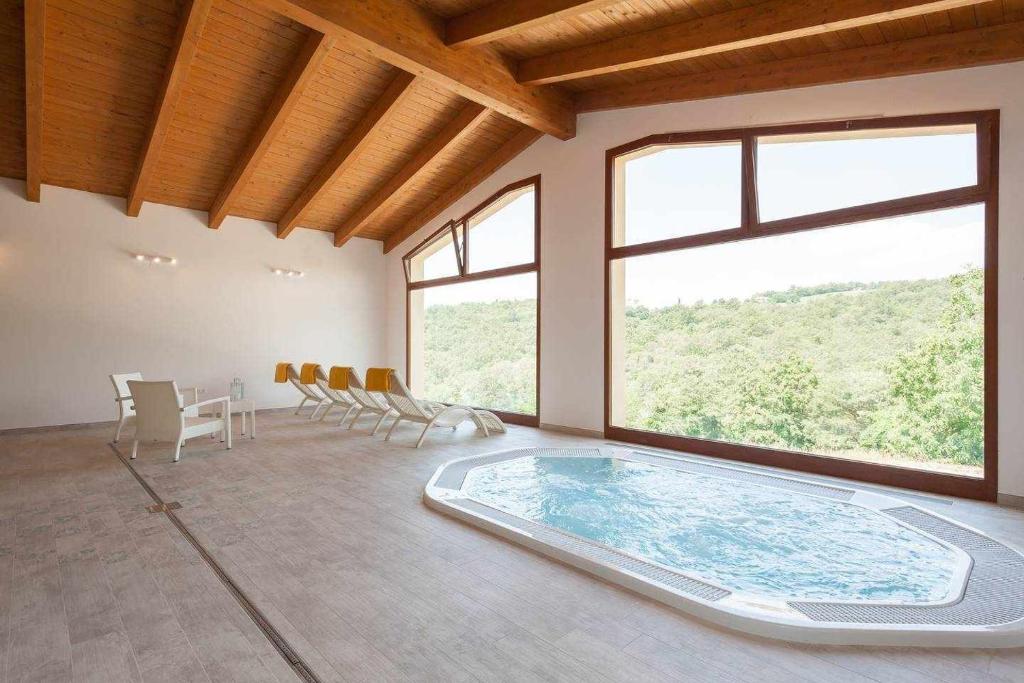 サンセポルクロにあるVilla Cantone e SPA piscina privataのテーブルと椅子付きの客室内の大きなスイミングプールを提供しています。