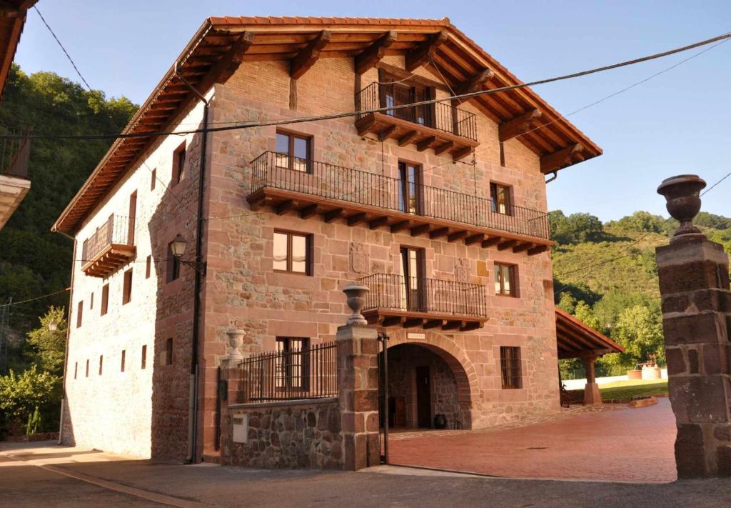 un gran edificio de ladrillo con balcón. en Casa rural Barbenea, en Oronoz-Mugaire