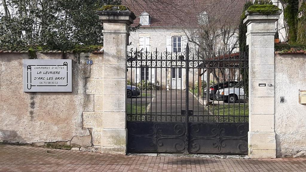 Una puerta a una casa con un cartel. en La Levriere d'Arc les Gray Chambre D'hotes, 