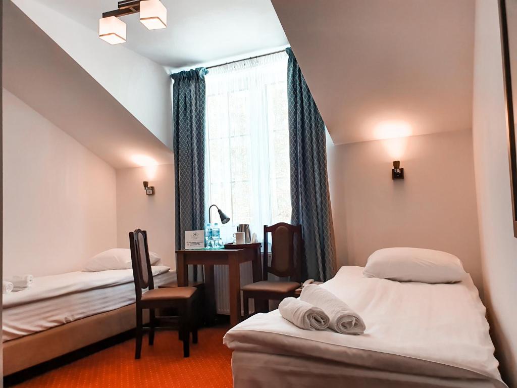 Lubycza KrólewskaにあるHotel "XAVIER"のベッド2台と窓が備わるホテルルームです。