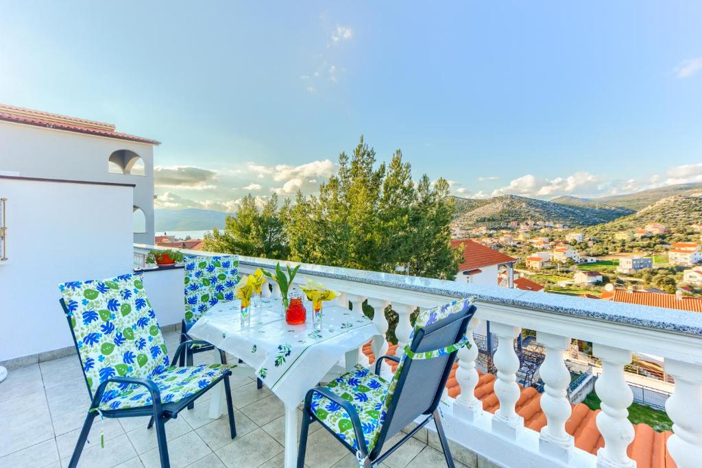 un tavolo e sedie su un balcone con vista di Villa Vittorio a Seget Vranjica