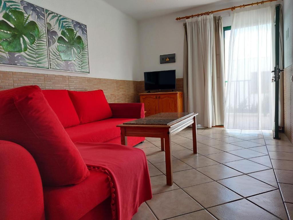 Televízia a/alebo spoločenská miestnosť v ubytovaní Apartamentos Acuario Sol
