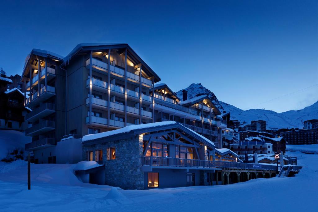 un hotel nella neve di notte di Hôtel Marielle a Val Thorens