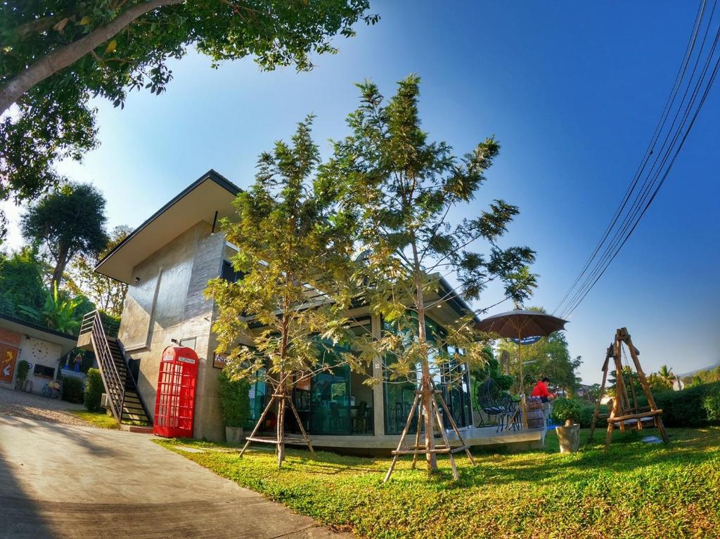 uma casa com uma cabine telefónica vermelha no quintal em Amante Baristro Hotel & Cafe' @Pua em Nan