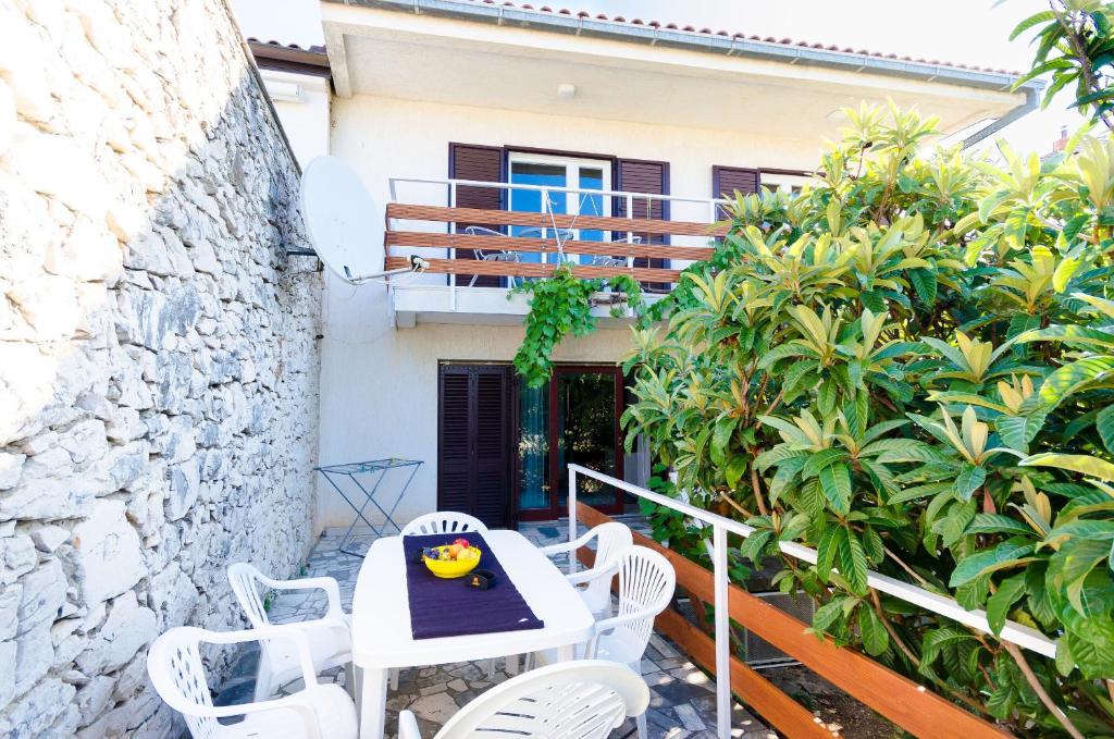 eine Terrasse mit Tisch und Stühlen und ein Gebäude in der Unterkunft House Andrijana in Novi Vinodolski