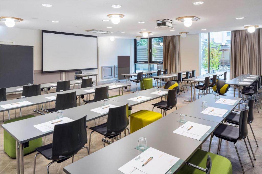 una classe con tavoli, sedie e schermo di proiezione di MAXX by Steigenberger Vienna a Vienna