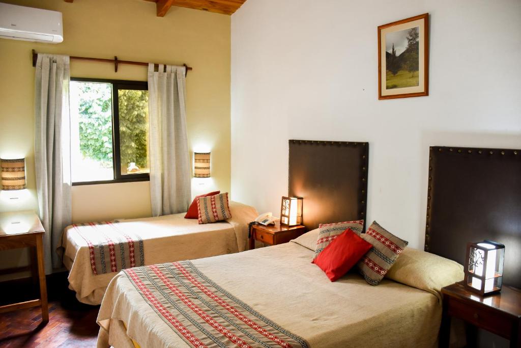 a hotel room with two beds and a window at Hotel Tafí in Tafí del Valle