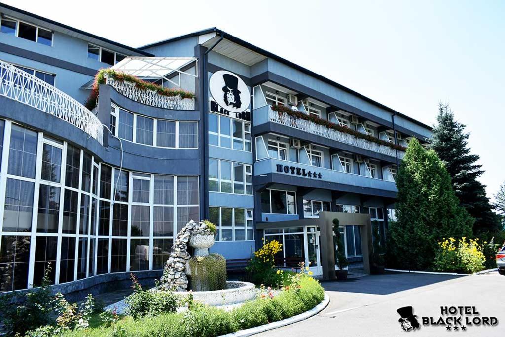 un bâtiment bleu avec un panneau à l'avant dans l'établissement Black Lord Hotel, à Târgu-Mureş