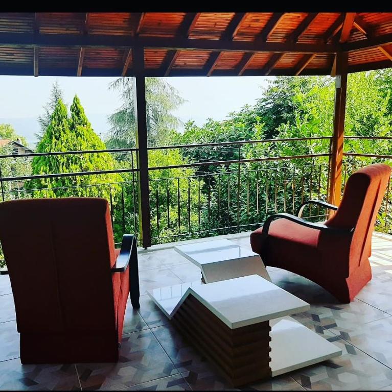 a patio with two chairs and a table and a balcony at Butik Hotel Maşukiye in Masukiye