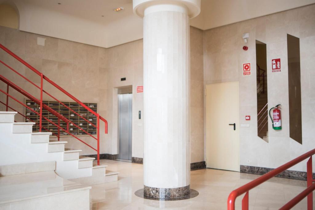 een grote witte zuil in een gebouw met trappen bij Beautiful first line beach apartment Samil in Vigo