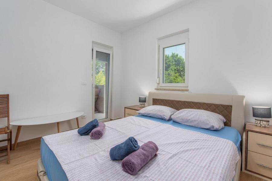 - une chambre avec un lit doté d'oreillers violets dans l'établissement Irma Apartment, à Dajla