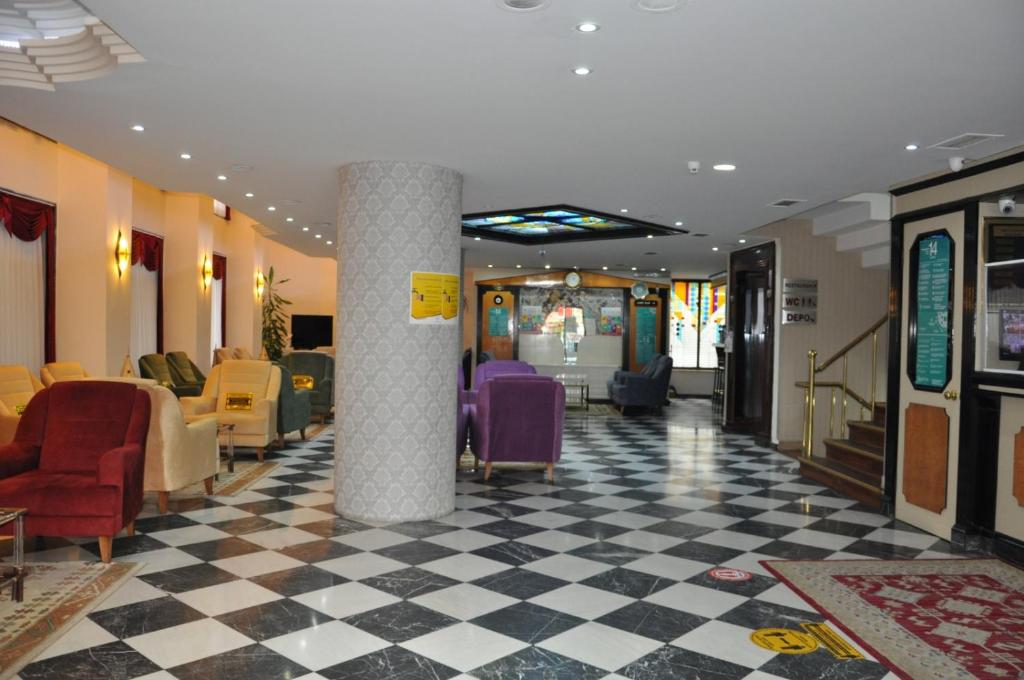 un vestíbulo con sillas y mesas en un edificio en Tayhan Hotel, en Estambul