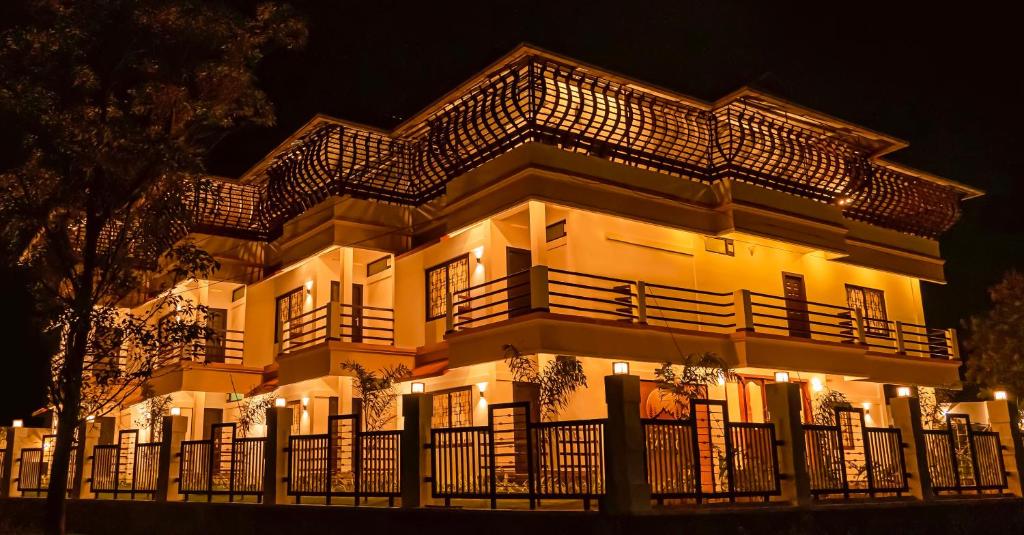 a building with a fence in front of it at night at Vagamon Vagashore in Vagamon