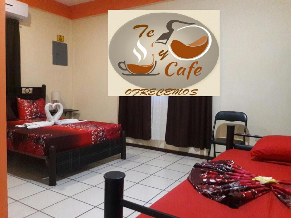 um quarto com duas camas e um sinal para um café em Alme Hostel em Playa del Carmen