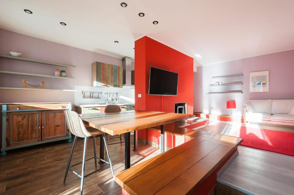 een keuken met een houten tafel en rode muren bij Appartamento La Pigna - Affitti Brevi Italia in Bardonecchia