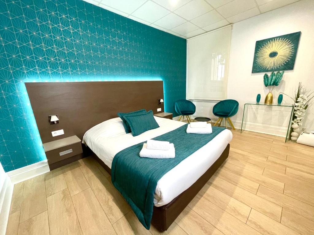 1 dormitorio con 1 cama grande y pared azul en Appart' Weekly Quartier Impérial Gare, en Metz