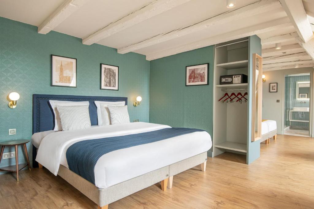 um quarto com uma cama grande e paredes verdes em Hôtel de l'Europe by HappyCulture em Estrasburgo