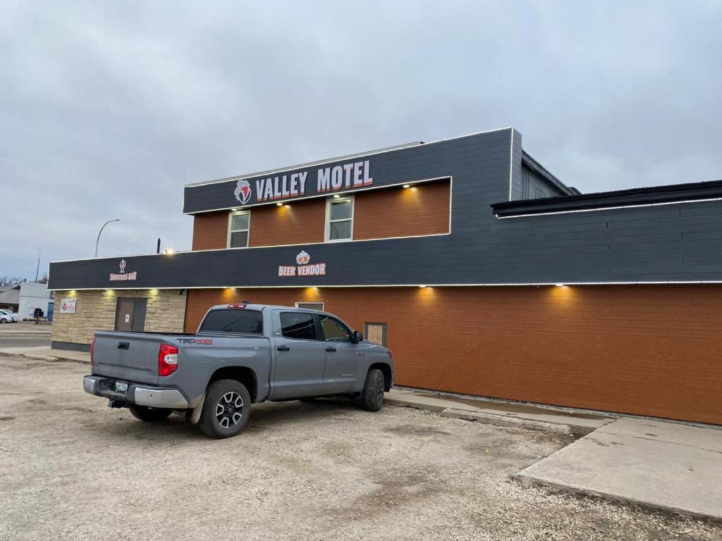 a gray truck parked in front of a building at Valley Motor Lodge in Minnedosa