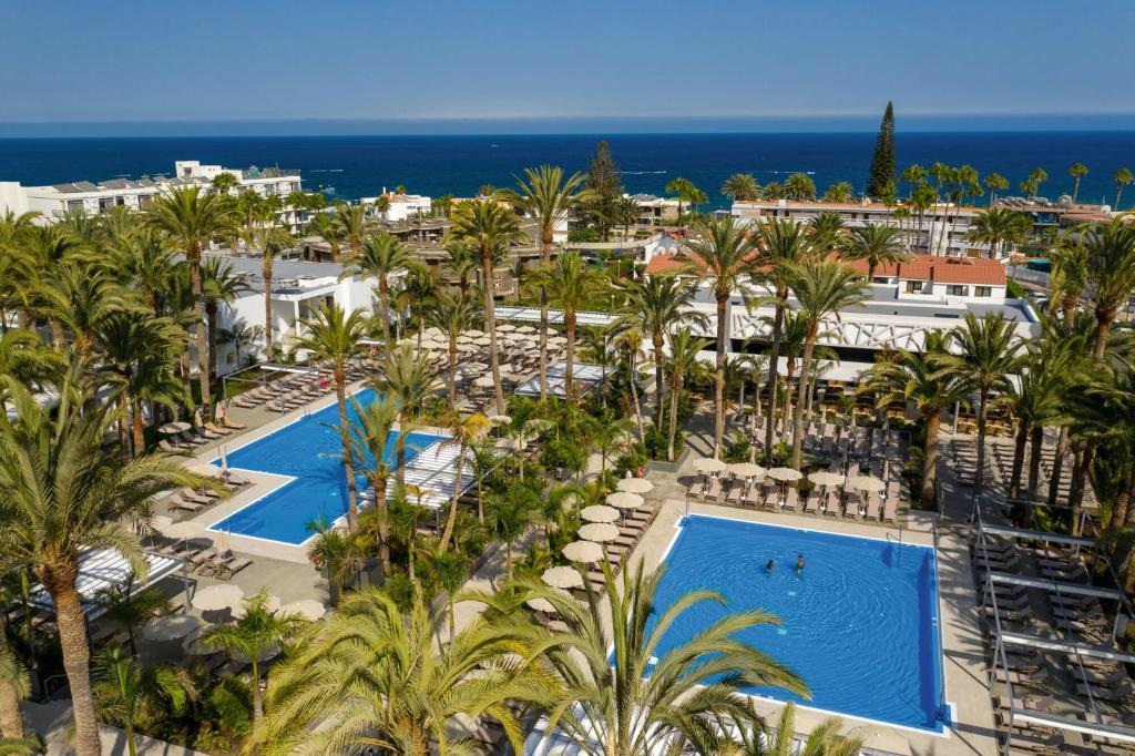 an aerial view of a resort with two pools and palm trees at Hotel Riu Palace Palmeras - All Inclusive in Playa del Ingles