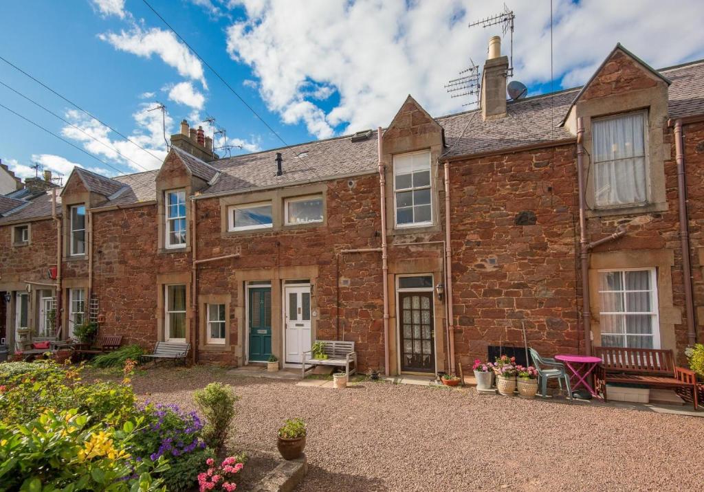 uma vista exterior para uma casa de tijolos com um pátio em Rockpool Apartment em North Berwick