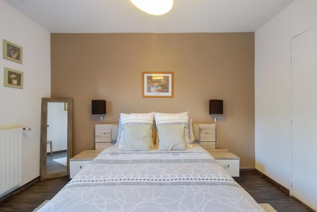 um quarto com uma cama grande com lençóis brancos e almofadas em Jasmin em Rouen