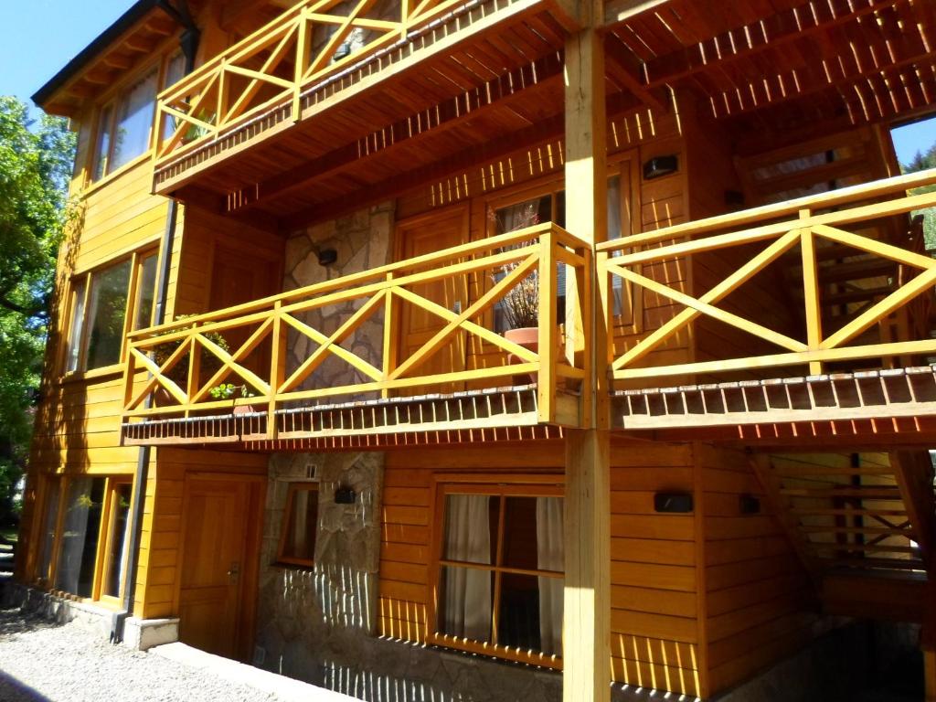 un edificio de madera con balcones en un lateral. en Apart Hotel Robles del Sur en San Martín de los Andes