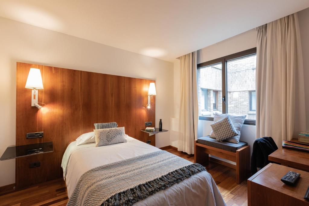 a hotel room with a bed and a window at Micampus Pamplona in Pamplona