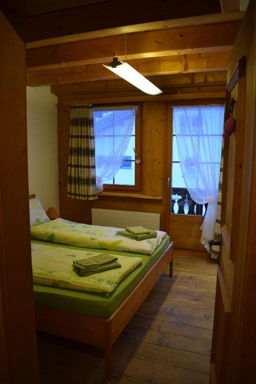 a bedroom with two beds and two windows at B&B Stiffler-Huus in Davos