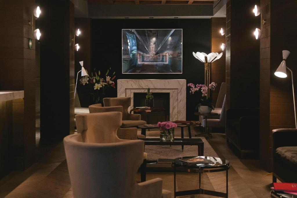 a living room with chairs and a fireplace at Brick Hotel Mexico City - Small Luxury Hotels of the World in Mexico City