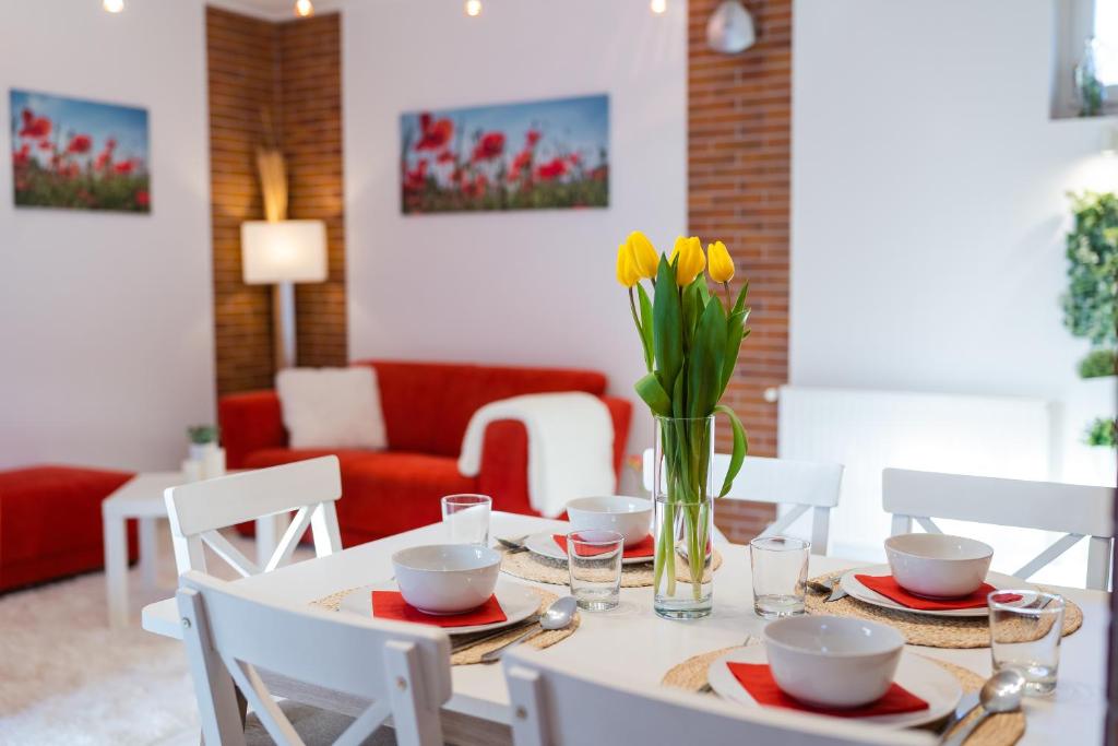 een eettafel met een vaas met bloemen erop bij Sára-Lux Apartman in Nyárliget