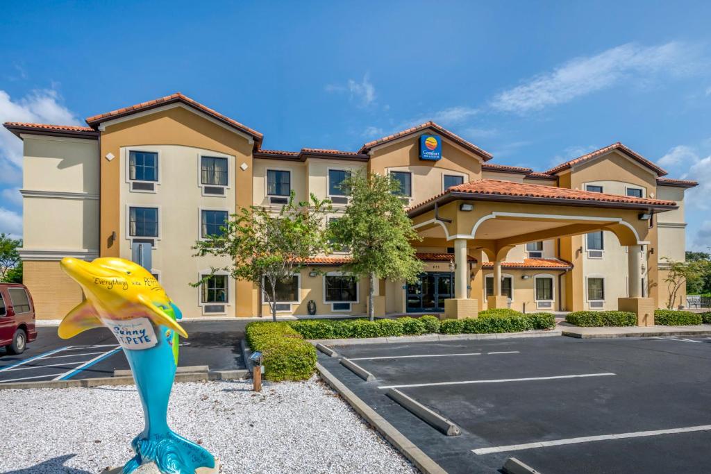 a hotel with a mermaid statue in front of a parking lot at Comfort Inn & Suites Northeast - Gateway in St. Petersburg