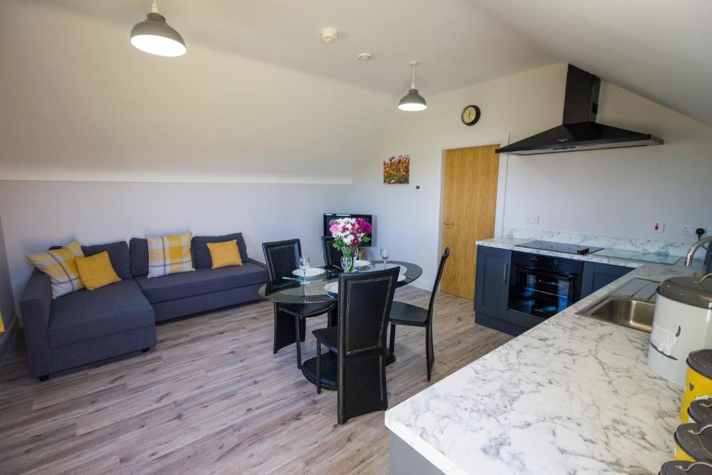 eine Küche und ein Wohnzimmer mit einem Sofa und einem Tisch in der Unterkunft Holllie View in Enniskillen